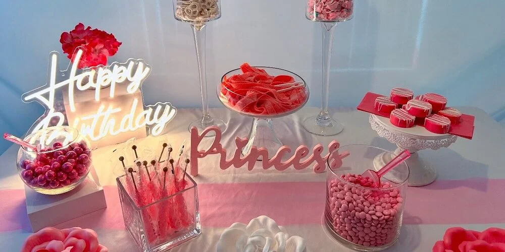Princess themed candy buffet with pink, red and white candy and roses